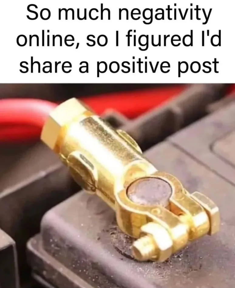 A close-up photo shows a gold-colored car battery terminal clamp attached to a dark gray battery, with a red cable visible…