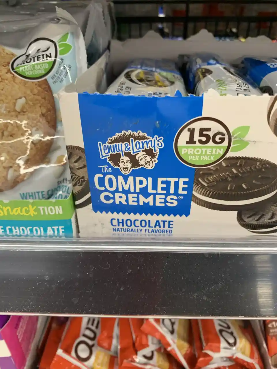 A close-up of a grocery store shelf displaying a box of Lenny & Larry's 'The Complete Cremes' chocolate cookies, which…