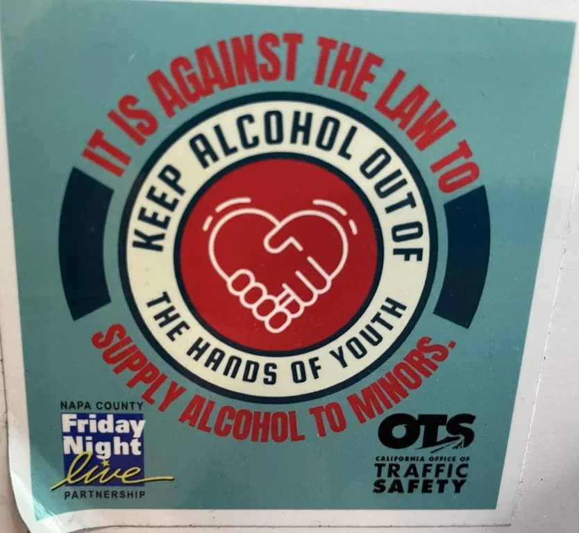 A public service announcement sticker with a red circle containing a white handshake icon, surrounded by text stating it is…