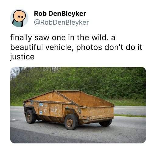 A rusty, dilapidated dump truck is shown on a road with trees in the background. Overlaid text reads 'finally saw one in the…