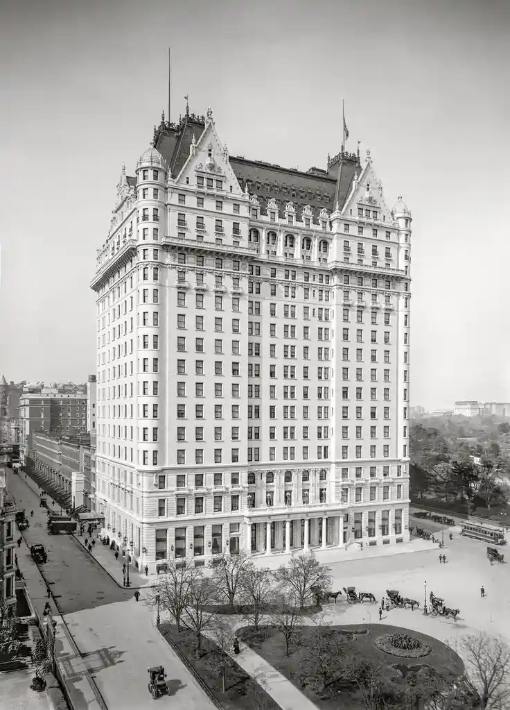 A black-and-white historical photograph shows the grand, ornate Plaza Hotel in New York City, featuring its iconic…