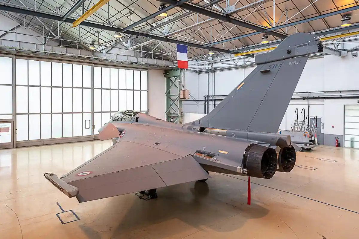 A grey French Dassault Rafale fighter jet, marked with the number 359 and the word 'RAFALE' on its tail, is parked inside a…
