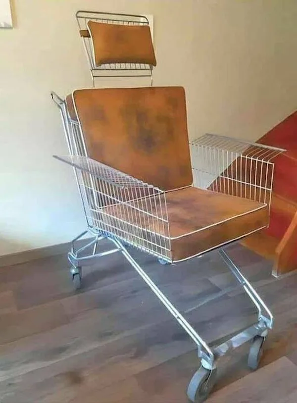 A shopping cart has been modified into a chair with brown cushions on the seat and backrest, and a small pillow on the top…