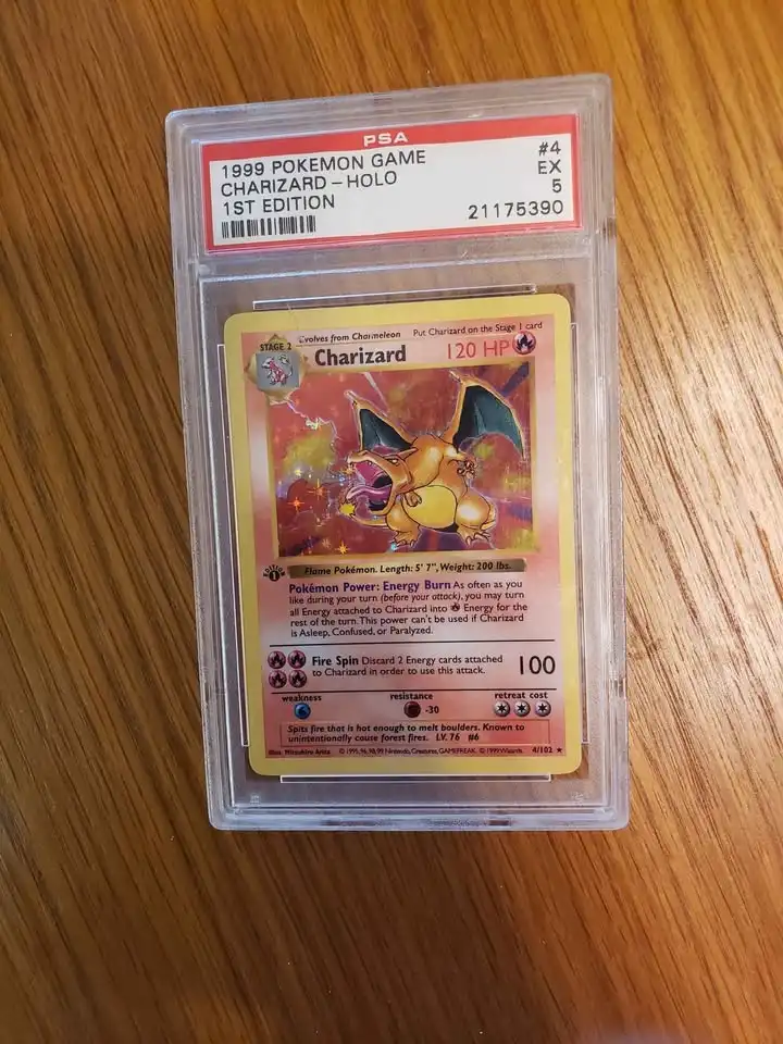 A 1999 first edition holographic Charizard Pokémon trading card, graded PSA EX 5, is encased in a protective plastic slab…