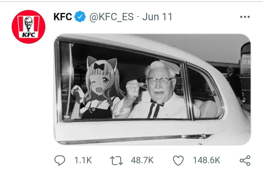 A black-and-white photo shows Colonel Harland Sanders in a car, smiling and waving, next to an anime girl with cat ears and…