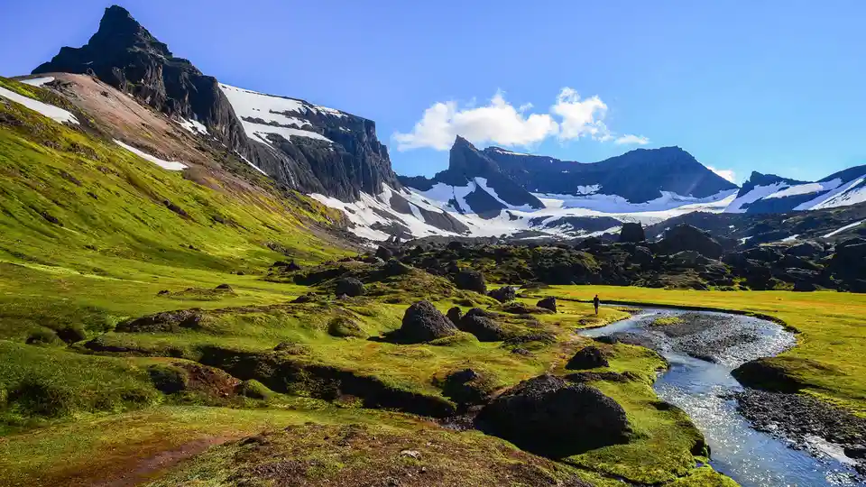 Rugged mountains meet serene valley landscapes in Iceland's StÃÂ³rurÃÂ°, where massive tuff boulders, forged by retreating…