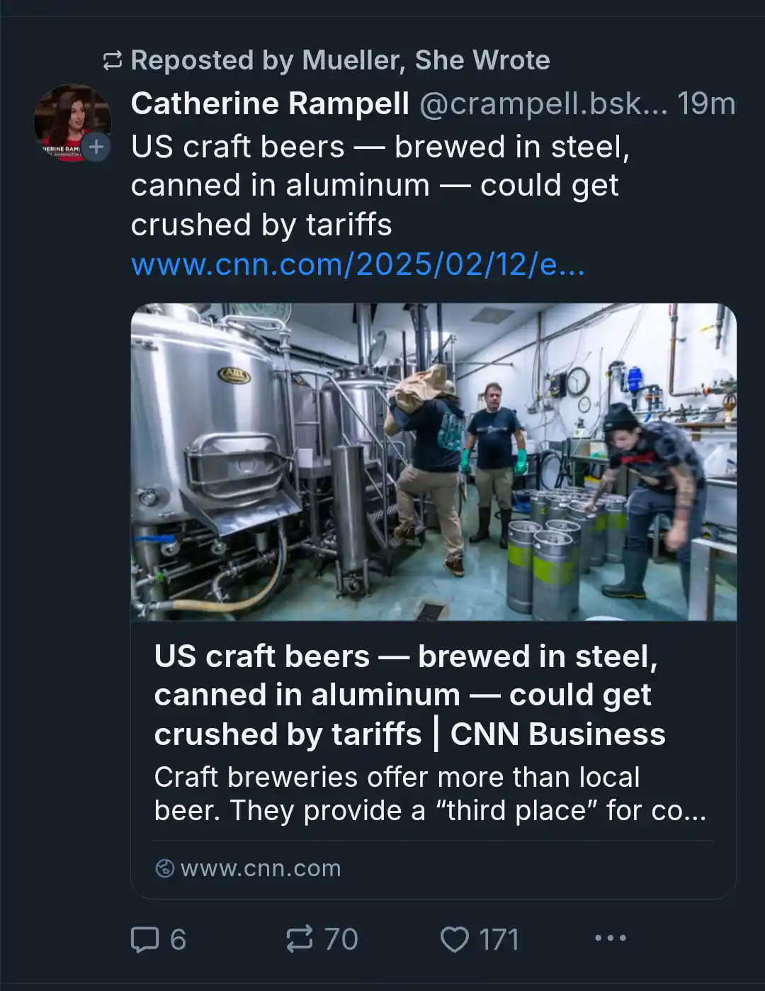 A photo shows three workers in a brewery with large stainless steel fermentation tanks and stacks of aluminum kegs. The…