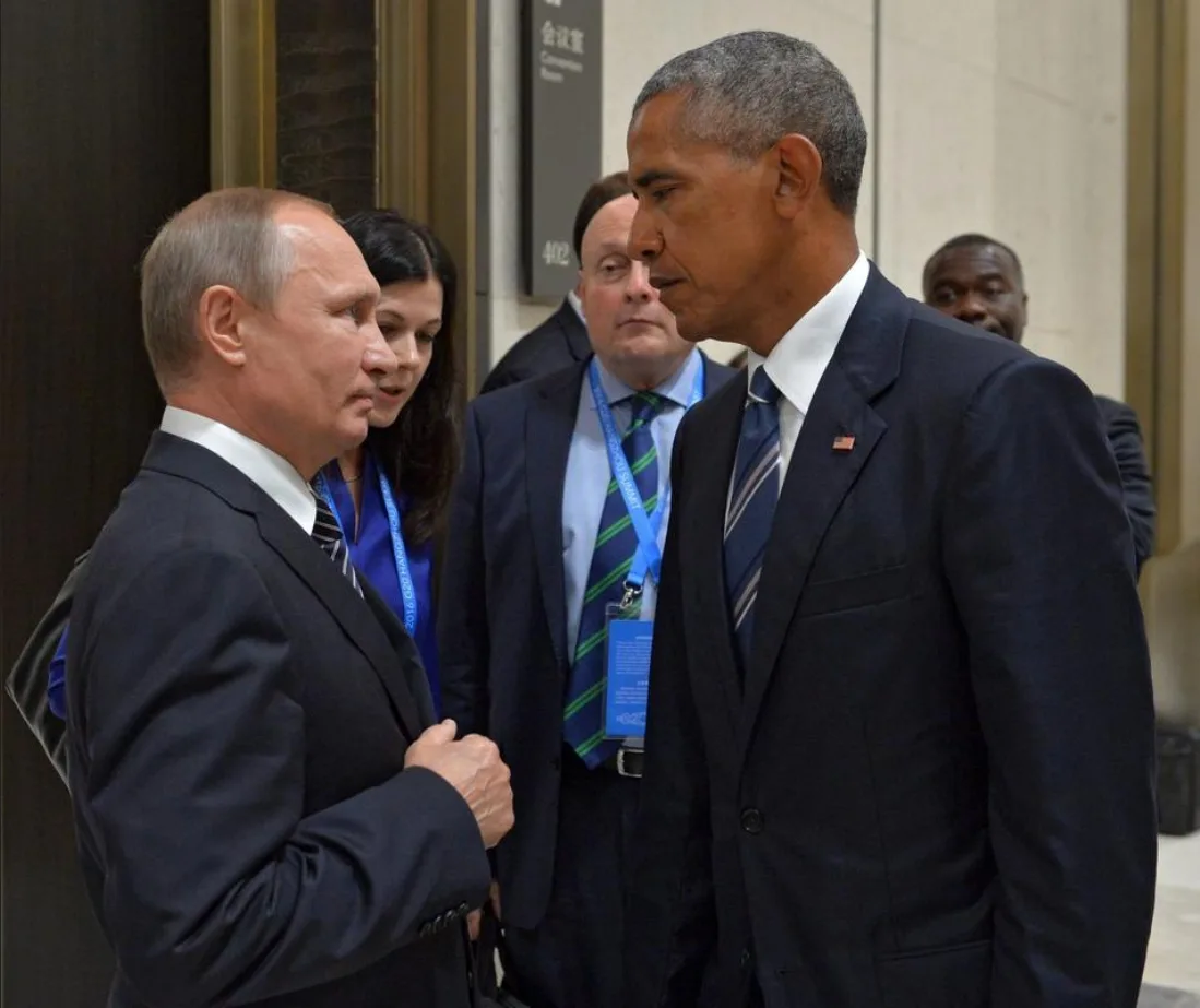 A photo shows former U.S. President Barack Obama and Russian President Vladimir Putin standing face-to-face in a hallway…