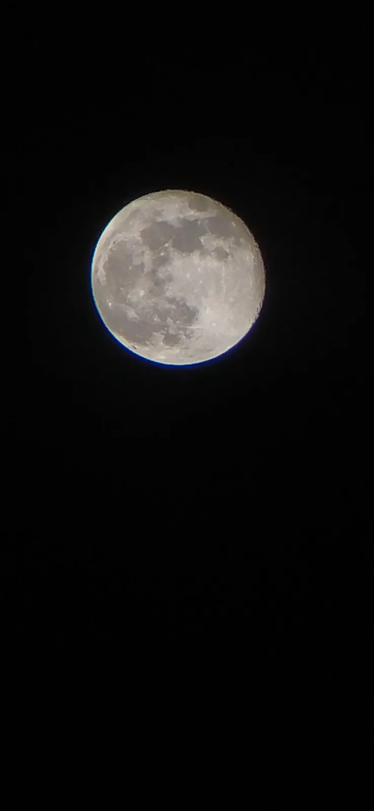 A full moon is centered in a black night sky, showing visible craters and surface details. There is no overlaid text or…