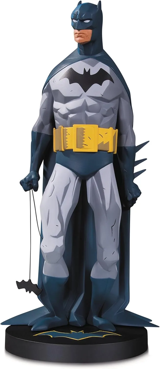 A full-body statue of Batman in a stylized, angular costume with a yellow utility belt, standing on a black base with a bat…