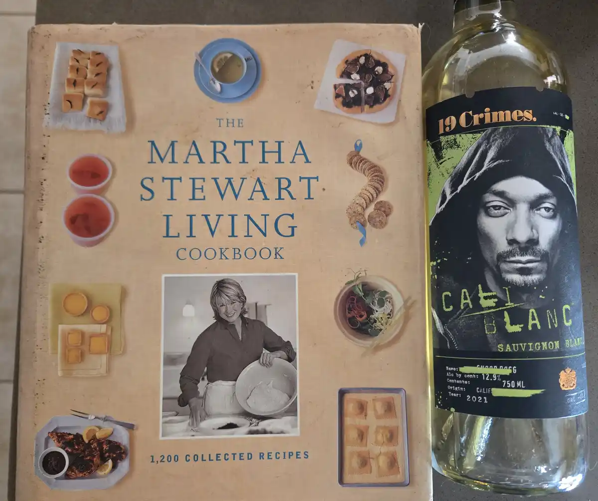A copy of 'The Martha Stewart Living Cookbook' sits next to a bottle of '19 Crimes' wine. The wine label features a portrait…