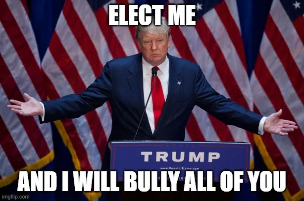 A man in a dark suit and red tie stands at a podium with 'TRUMP' written on it, arms spread wide, in front of multiple…