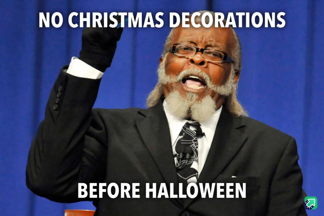 A man in a black suit and glasses, with a white beard and black gloves, raises his right fist in a passionate gesture…