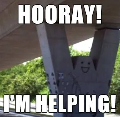 A concrete pillar under an overpass has a crudely drawn smiling face on it, with bold white text overlaid that reads…