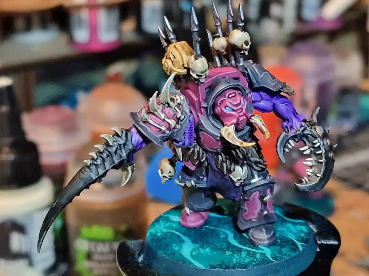 A highly detailed, painted fantasy miniature of a monstrous orc-like warrior with purple skin, wielding a spiked weapon and…