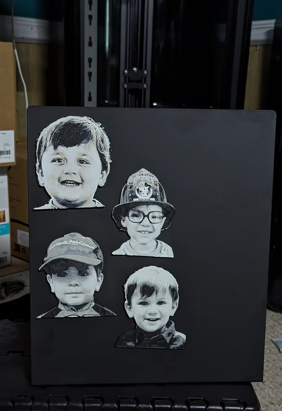 A black rectangular surface displays four stylized, textured portraits of young boys. The top-left boy smiles broadly. The…