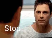Six identical frames show a man in a hospital gown staring intensely at another person whose back is to the camera. The text…