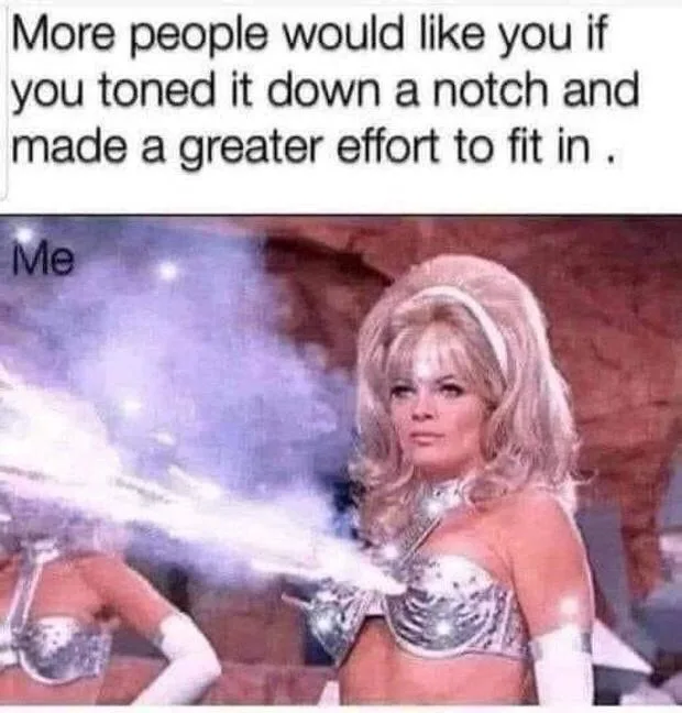 A woman in a silver, futuristic costume with a large, voluminous blonde wig stands confidently, blasting a bright beam of…