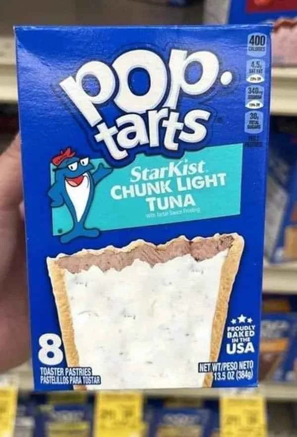 A hand holds a blue Pop-Tarts box with a fictional flavor: 'Starkist CHUNK LIGHT TUNA with tartar Sauce Filling'. The box…