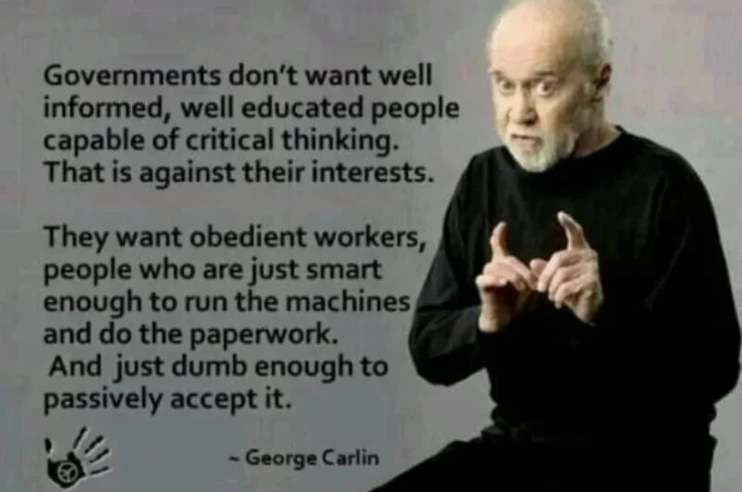 A man with a white beard and black shirt gestures emphatically while text overlaid on the image quotes George Carlin…