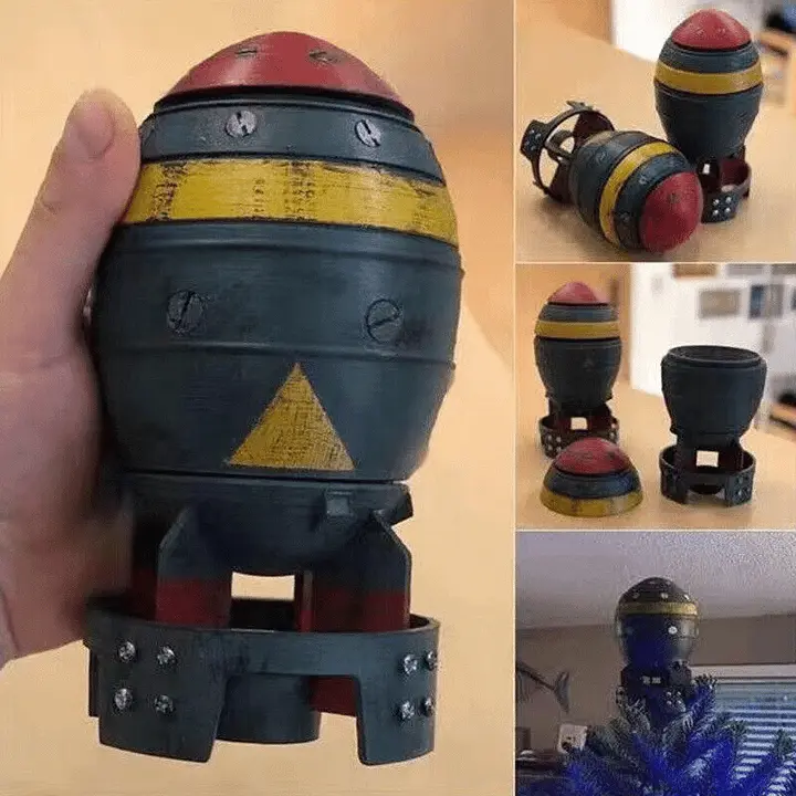 A collage shows a hand holding a 3D-printed replica of a cartoon bomb with a red top, black body, yellow stripe, and warning…