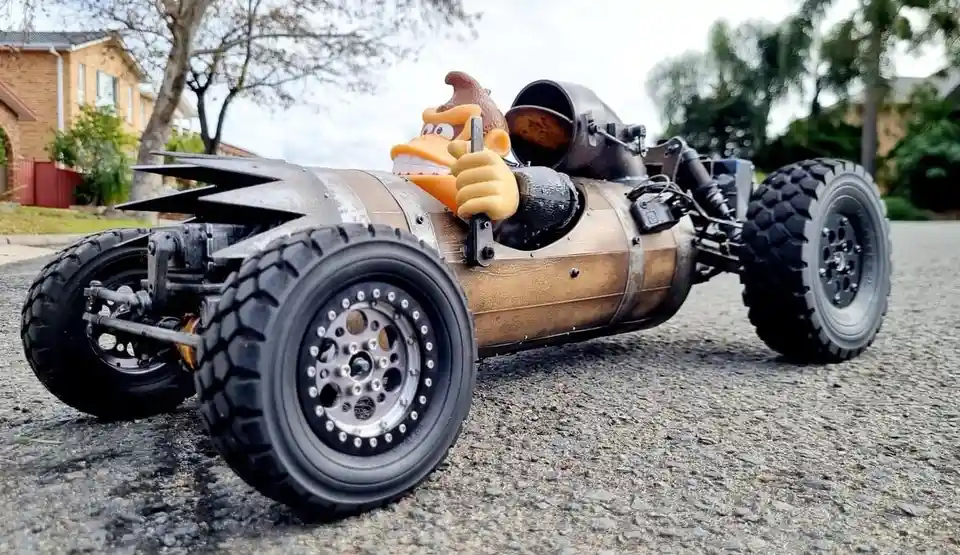 A custom-built, rugged remote-controlled vehicle resembling a barrel with large off-road tires and exposed mechanical parts…