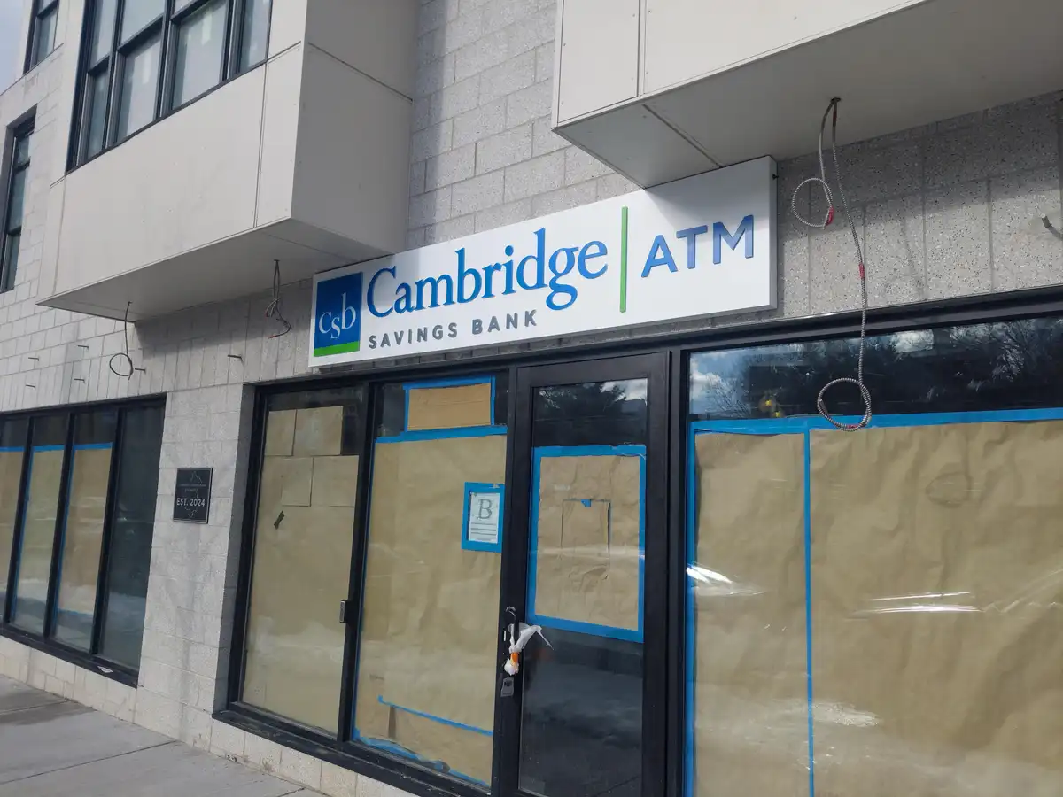An exterior shot of a Cambridge Savings Bank ATM location with its windows and doors covered in brown paper and blue…
