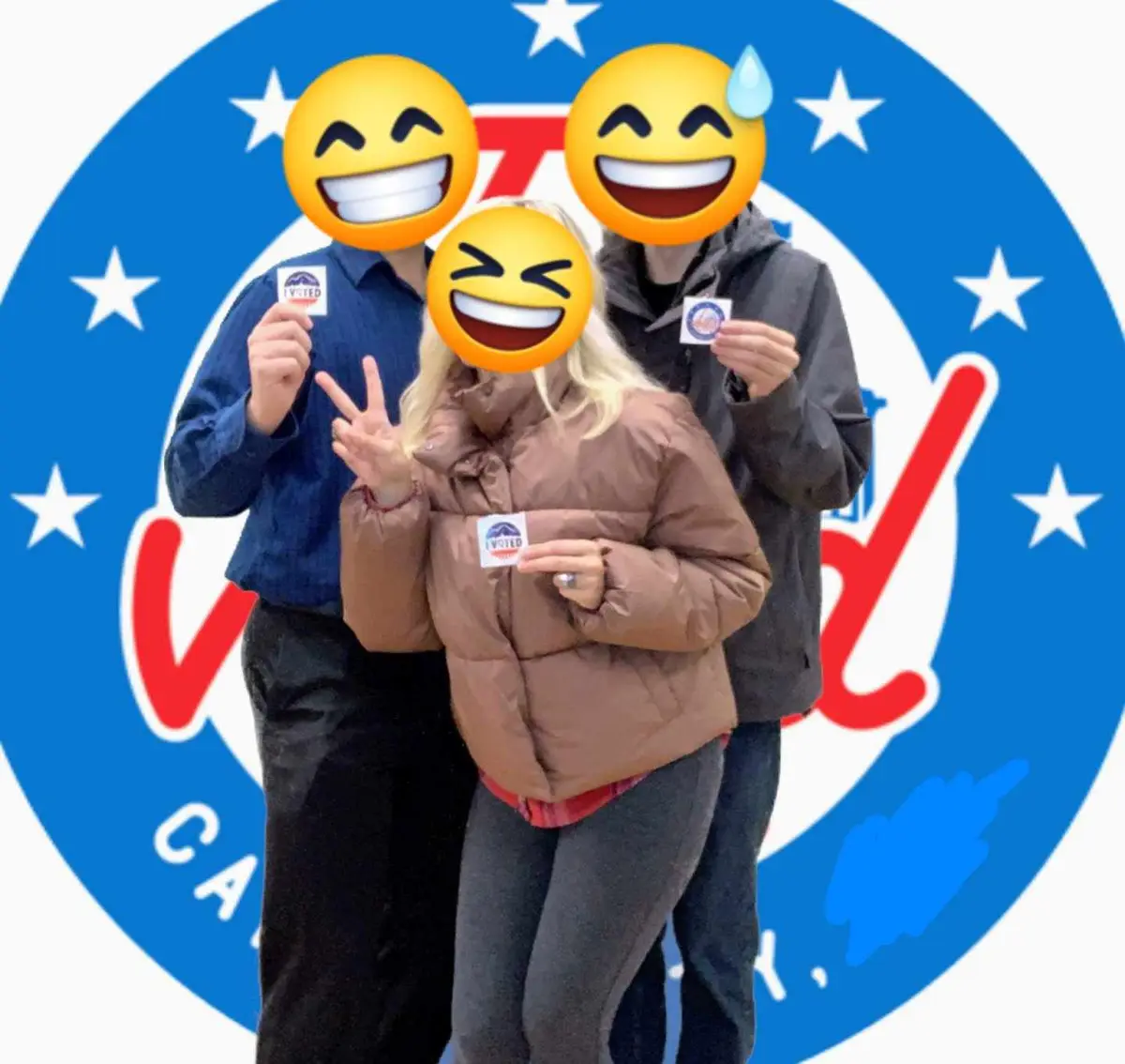 Three people stand together, each holding an 'I VOTED' sticker, with their faces obscured by laughing emojis. The background…