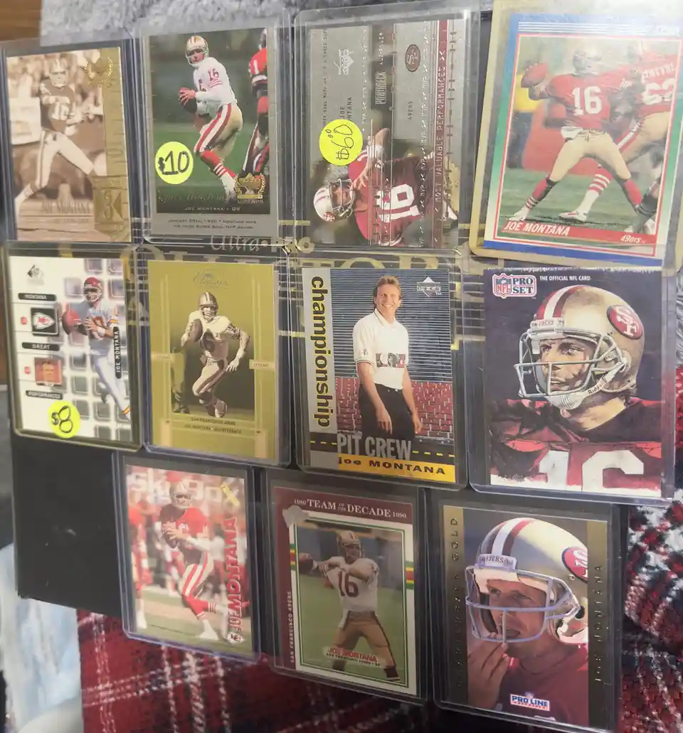 A collection of nine different Joe Montana NFL trading cards, each in protective sleeves, displayed together. The cards…