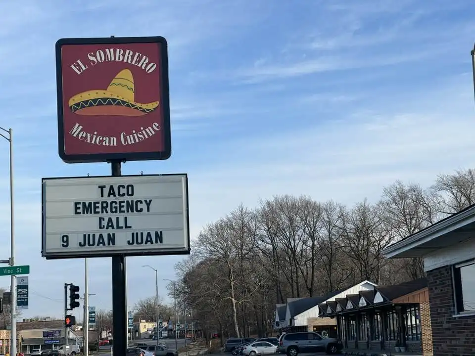 A photo of a restaurant sign for 'El Sombrero Mexican Cuisine' with a sombrero logo, below which a marquee board reads 'TACO…