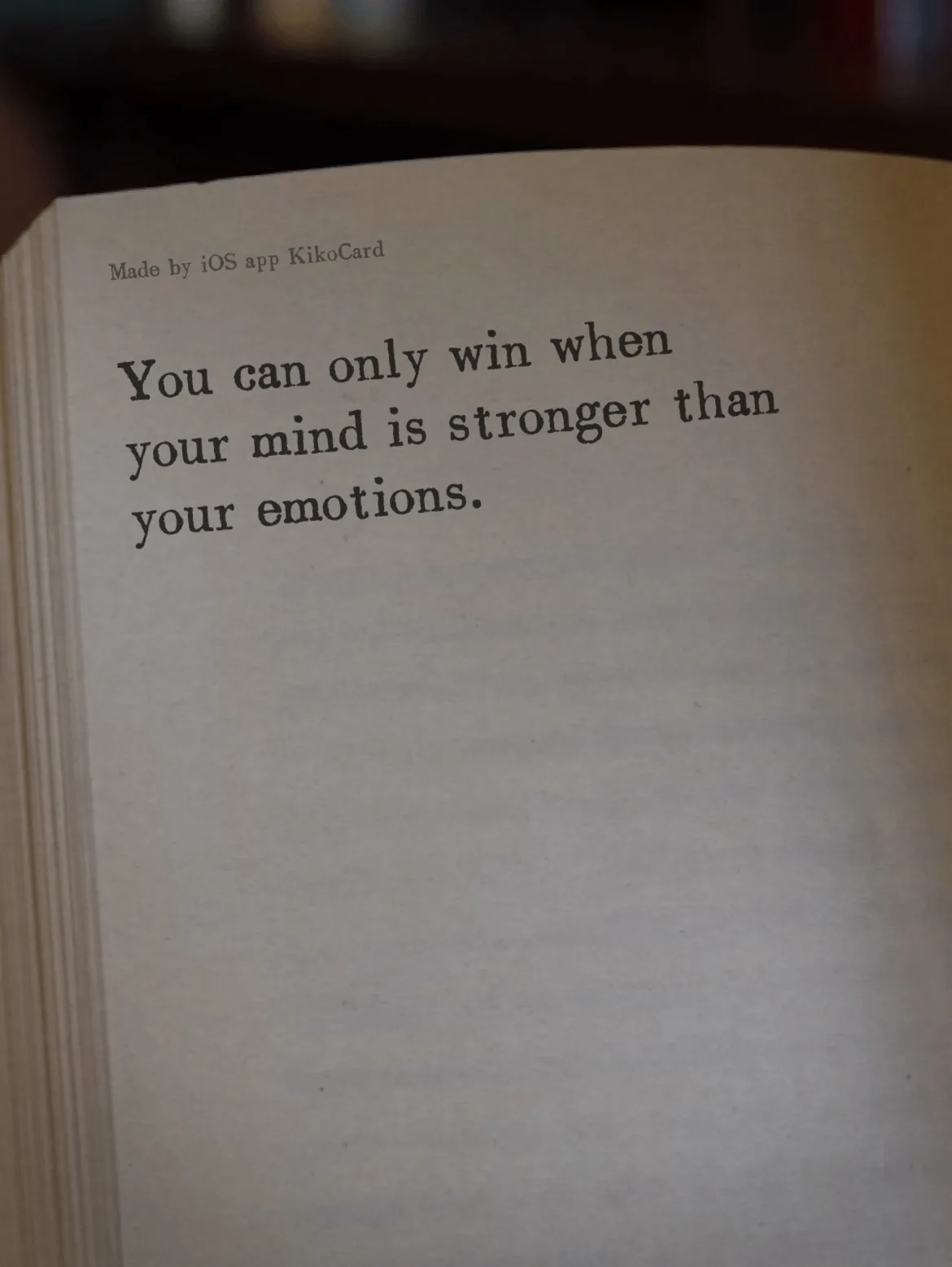 A close-up photo of a physical card or printed page with the motivational quote 'You can only win when your mind is stronger…