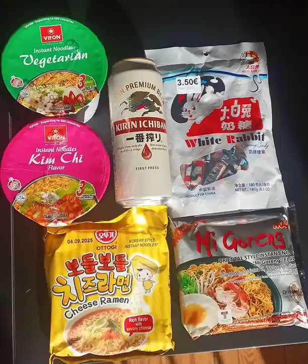 A flat-lay photo displays five Asian snack items: two VIFON instant noodle cups (vegetarian and kimchi flavor), a can of…