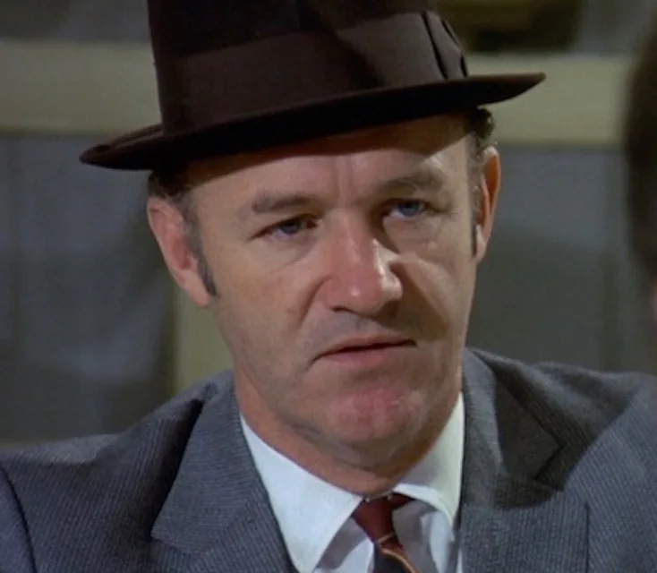 a close-up of a man in a brown fedora and gray suit with a serious, intense expression, overlaid with the text 'i'm gonna…