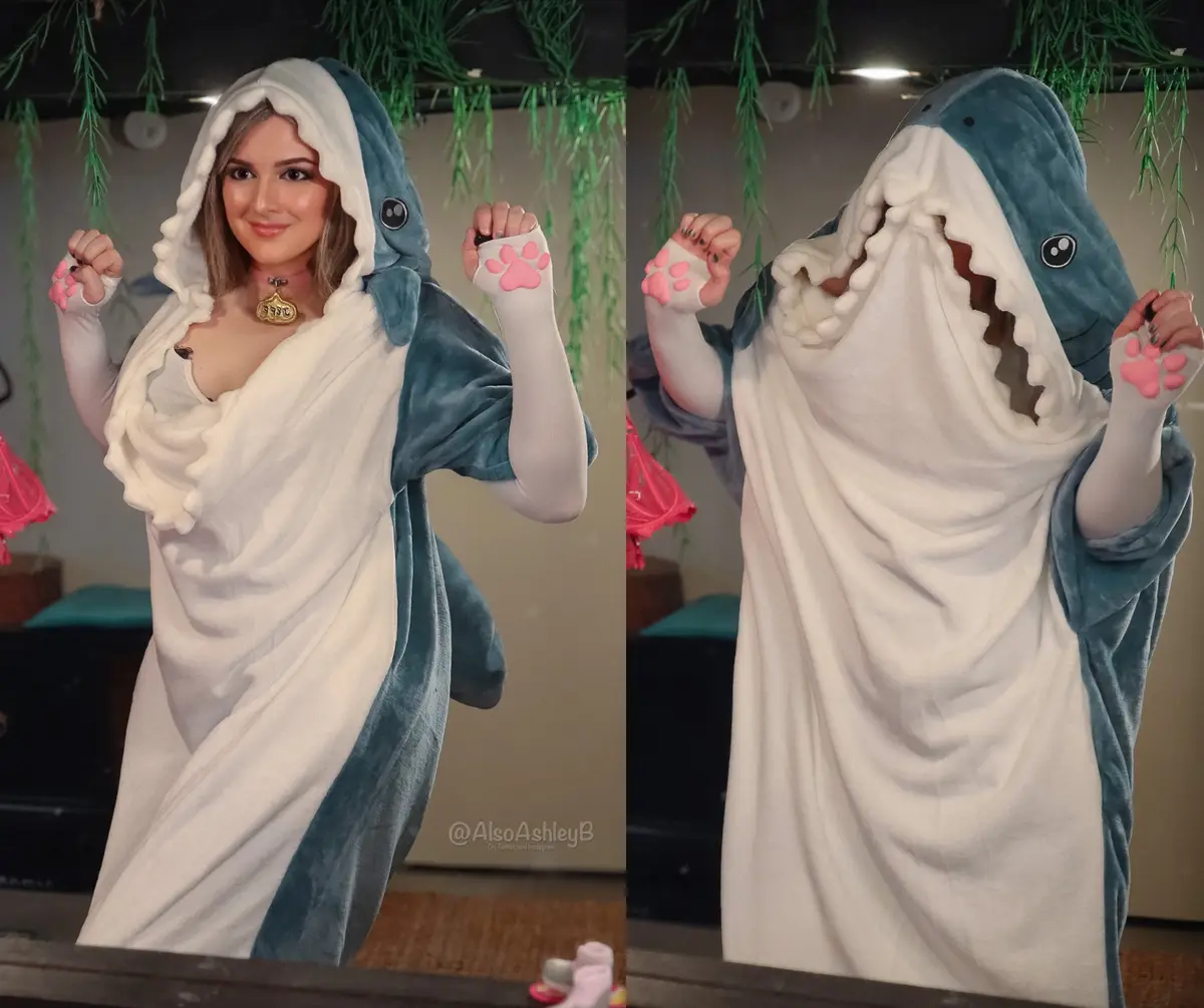 A split-image shows a person in a shark-themed onesie. On the left, they smile with their face visible. On the right, they…