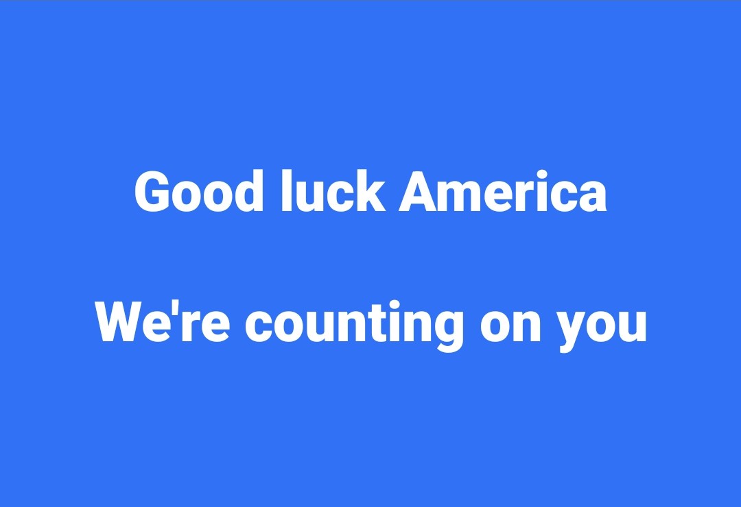 A solid blue background with two lines of white text centered: 'Good luck America' on the top line and 'We're counting on…