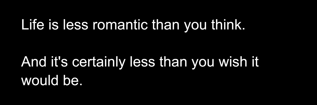 A black background with two lines of white text. The first line reads 'Life is less romantic than you think.' The second…